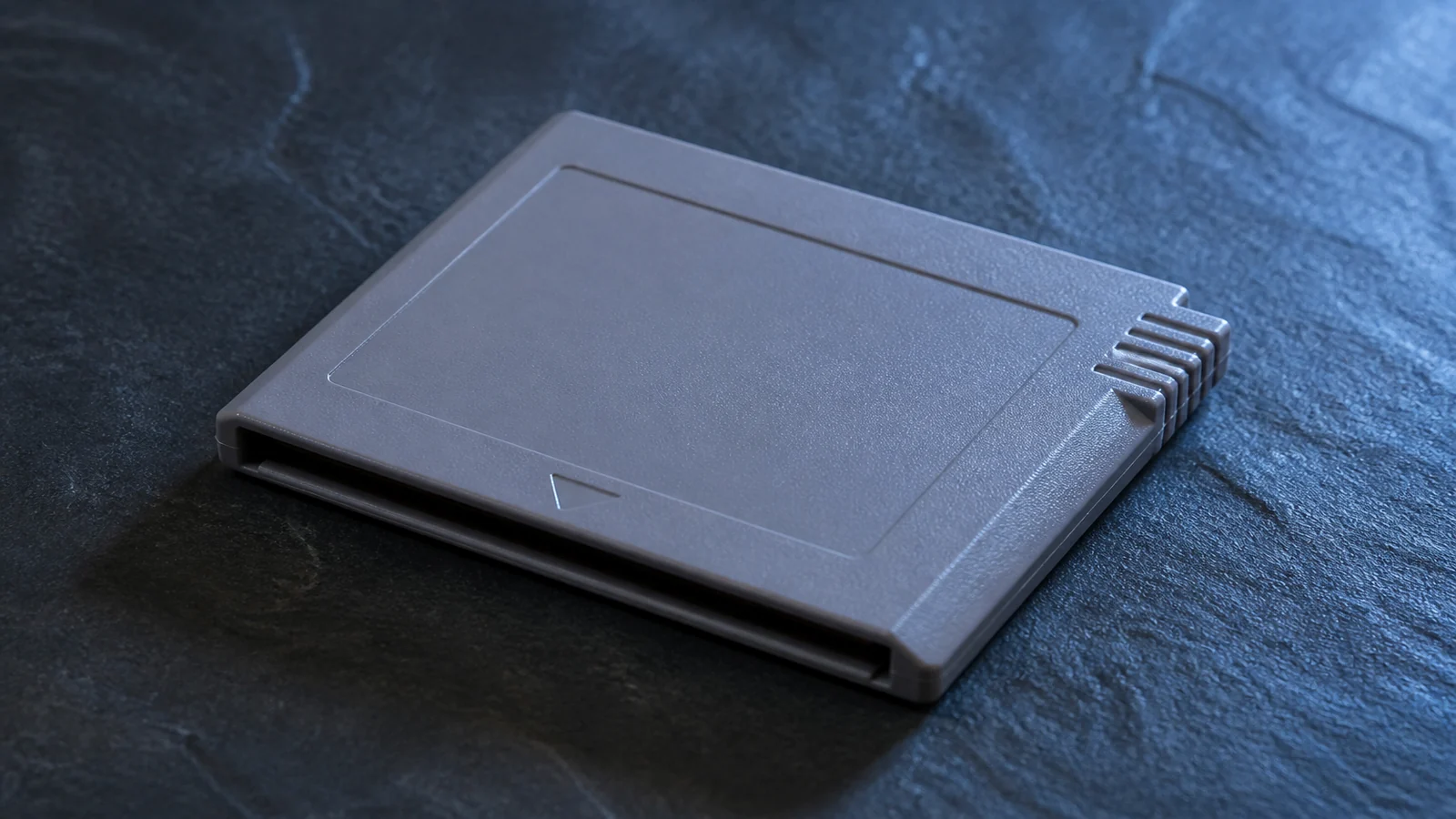 Blank gray game cartridge on dark slate